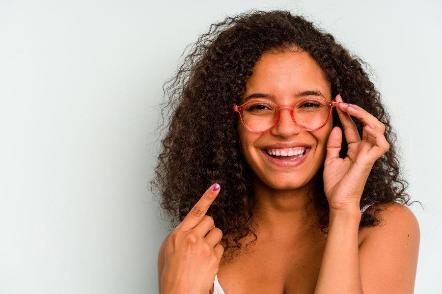 Mulher sorridente apontando para os óculos