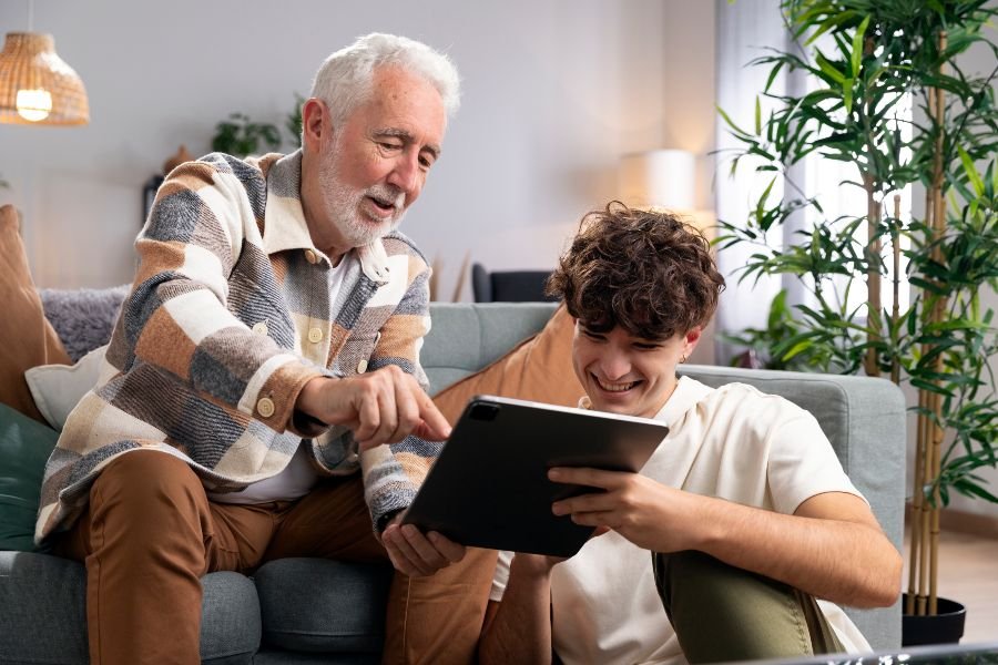 Idoso e jovem usando tablet